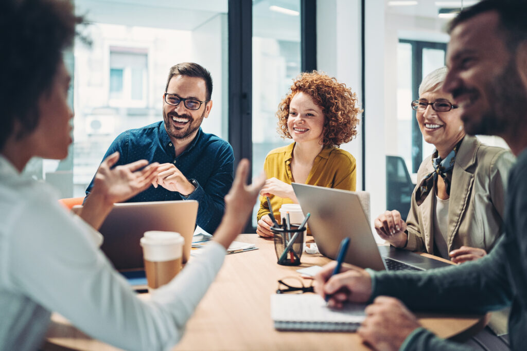 Drive Transformational Experiences - Business people sitting around the table and talking