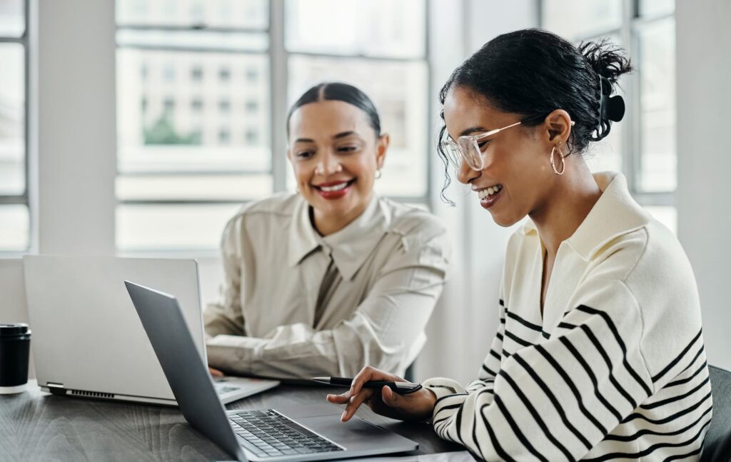 Communications strategy - Two young women working on laptops at a table.

