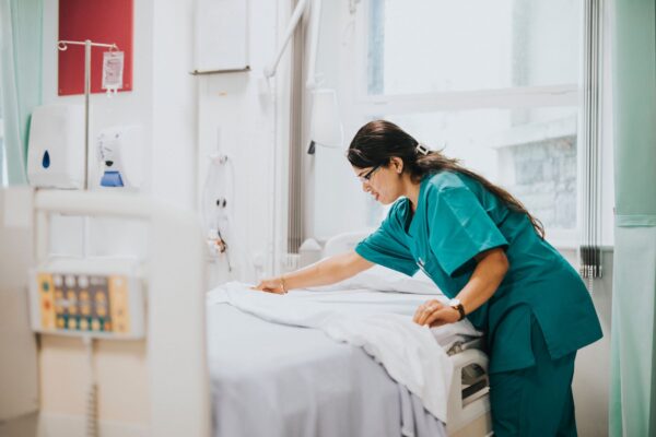 Somerset NHS - Nurse setting bedsheets in a hospital room