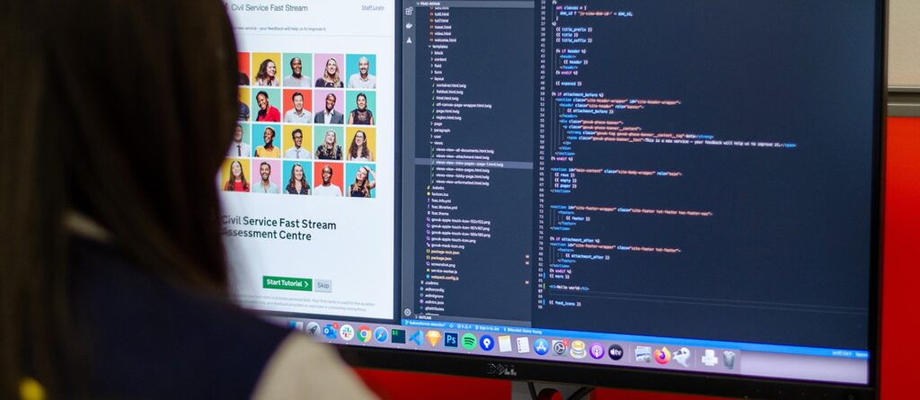 FSAC developer working at a screen on the code base for the Drupal digital platform with a monitor display