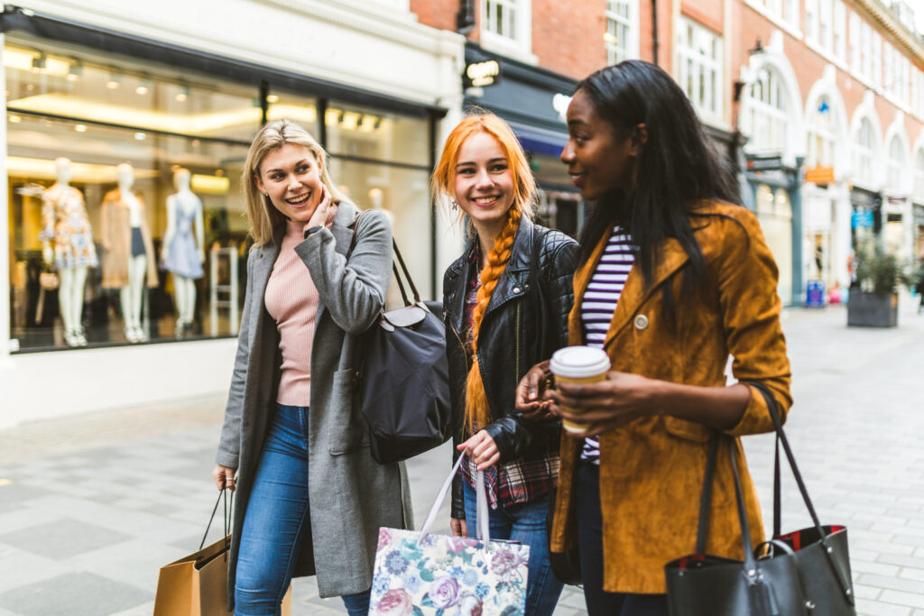 Ocean Consumer Lifestyle Database - Three women shopping together in front of a clothing store